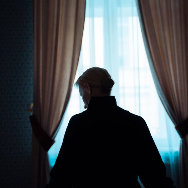Person sitting in a calm meditation pose in a softly lit room.